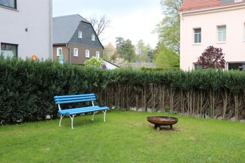 a blue bench sitting in the grass next to a stool at XXL Ferienliebe in Habrachćicy