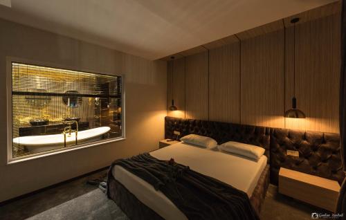 a bedroom with a large bed and a bath tub at Vera HOTEL-VILLA in Pristina