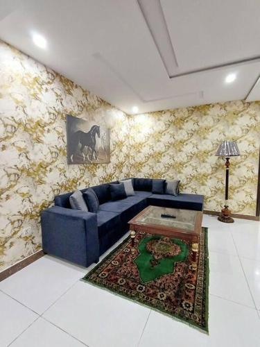 sala de estar con sofá azul y mesa en 501-NEXT INN Cozy apartment for your stay.., en Lahore