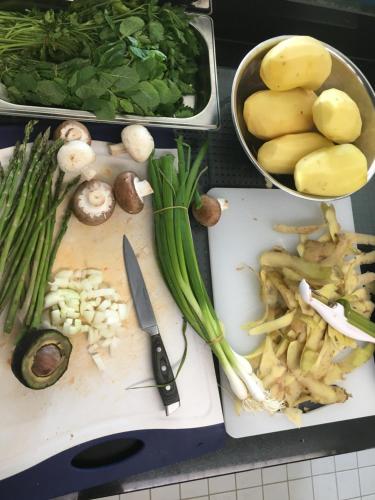 a bunch of vegetables on a cutting board with a knife at Hotel Schlossberg in Badenweiler