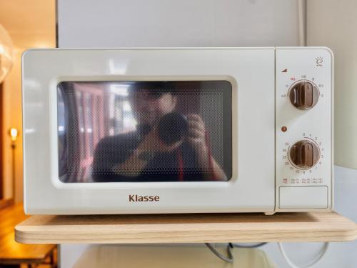 a man taking a picture in a microwave at Juin - Foreigner only in Seoul