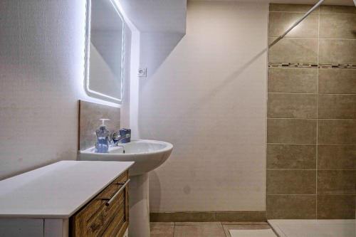 une salle de bain blanche avec un lavabo et une douche dans l'établissement Magnifique maison de ville - parking - proche Disney, à Fublaines