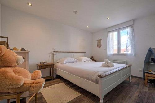 - une chambre avec un grand lit et un ours en peluche dans l'établissement Magnifique maison de ville - parking - proche Disney, à Fublaines