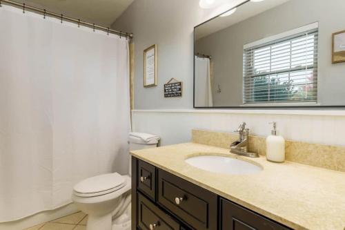 a bathroom with a sink and a toilet and a mirror at Gorgeous Alabama Home 4 Miles to Stadium Sleeps 8 in Tuscaloosa