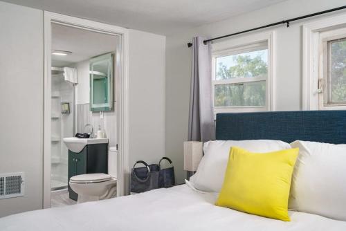 a bedroom with a bed with a yellow pillow on it at The Lucky Charm Home of the Fighting Irish! BBQ Outdoor Games Coffee in South Bend