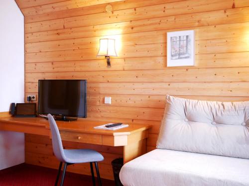 a bedroom with a desk with a bed and a television at Hotel Hochfirst in Lenzkirch