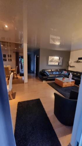 ein Wohnzimmer mit einem Sofa und einem Tisch in der Unterkunft Agréable maison au calme in Wittenheim