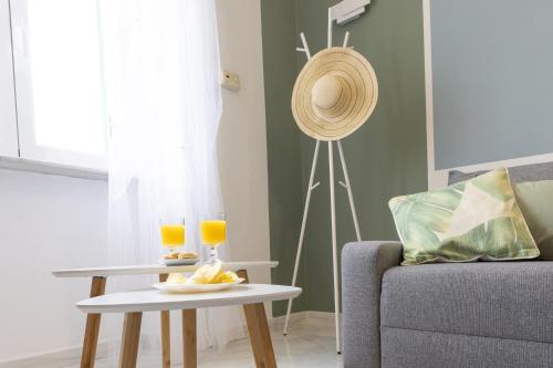un soggiorno con divano e tavolo con bicchieri di succo d'arancia di Verde Salmastro a Livorno