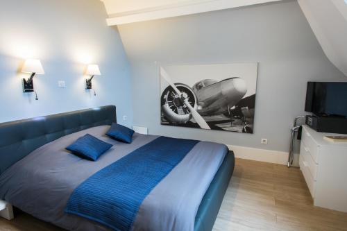 a bedroom with a bed and a picture of a car on the wall at Château de la Folie in Trie-Château
