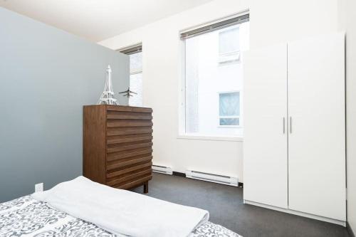 - une chambre avec un lit, une commode et une fenêtre dans l'établissement Premium 2BD Loft DT Heated Parking Rooftop Patio BBQ Gym Coffee, à Winnipeg