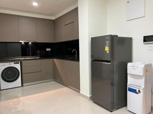 a kitchen with a refrigerator and a washer and dryer at ImPian II Residence @ The Peak in Phnom Penh