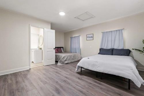 1 Schlafzimmer mit 2 Betten und einem Fenster in der Unterkunft The Lily Pad Modern Cottage In The City in Mobile