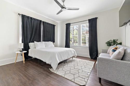 a white bedroom with a bed and a couch at Modern Escape in Historic District in Mobile