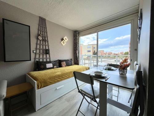 une chambre avec un lit et une table et une salle à manger dans l'établissement Appartement rénové avec 2 pièces et parking privé à Gruissan, proche plage du Grazel - FR-1-229-883, à Gruissan