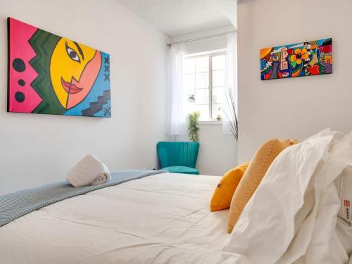 a bedroom with a bed with a painting on the wall at Fun and Colourful Condo w Foosball Parking Coffee in Calgary
