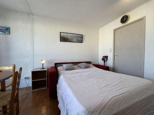 een slaapkamer met een groot bed en een tafel bij Appartement Gruissan, 1 pièce, 3 personnes - FR-1-229-882 in Gruissan