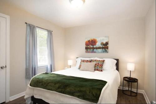 a white bedroom with a large bed and a window at The Cozy Retreat l 4-Bedrooms WiFi Long Stays in Birmingham