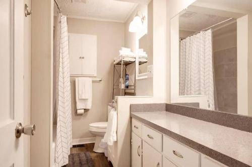 a white bathroom with a sink and a toilet at The Cozy Retreat l 4-Bedrooms WiFi Long Stays in Birmingham
