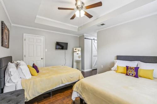 Un dormitorio con dos camas y un ventilador de techo. en Cozy Retreat in the Heart of Baton Rouge, en Baton Rouge