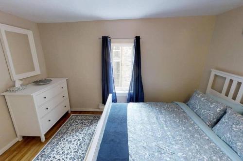 a bedroom with a bed and a dresser and a window at Charming Home Heart Of Uptown! Location! Coffee! in Saint John