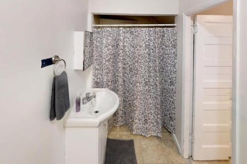 a bathroom with a sink and a shower curtain at Charming Home Heart Of Uptown! Location! Coffee! in Saint John