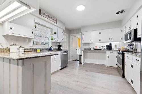 a large white kitchen with white cabinets and appliances at The Ranch 4-Bedrooms Large Yard & Patio in Mobile