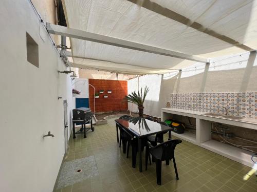 uma cozinha e sala de jantar com mesa e cadeiras em Villa indipendente sul mare - Maiolica home&welfare em Alcamo Marina