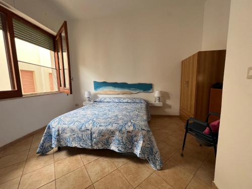 um quarto com uma cama com um edredão azul e uma janela em Villa indipendente sul mare - Maiolica home&welfare em Alcamo Marina