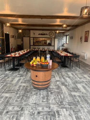 a dining room with tables and chairs and a bowl of fruit at La Colline aux Chalets, Jaccuzi, Sauna in Saint-Chamarand