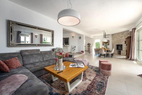 a living room with a couch and a table at Villa Bincila for 12 people near Poreč with sea view & beautiful garden in Labinci