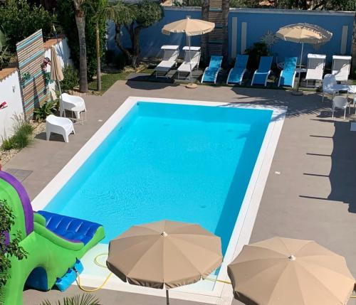 una piscina con sillas y sombrillas junto a ella en B&B Villa Eraclea, en Villaggio Mosè