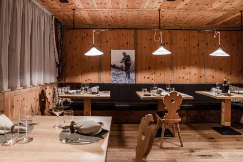 a restaurant with wooden walls and tables and lights at Monroc Hotel in Commezzadura