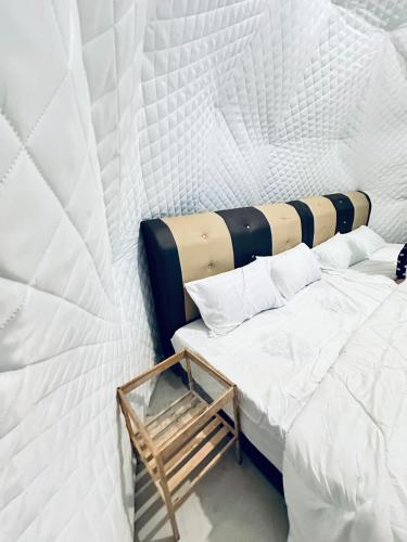 twee bedden in een kamer met witte muren bij Gunung Medan Glamping & Cafe in Kangar