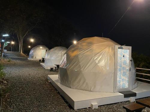 grupa namiotów na polu w nocy w obiekcie Gunung Medan Glamping & Cafe w mieście Kangar