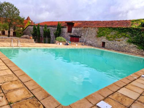 - une piscine en face d'un bâtiment d'eau bleue dans l'établissement Gîte Métairie, à Varaire