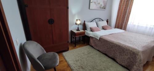 a small bedroom with a bed and a chair at Apartment.md in Chişinău