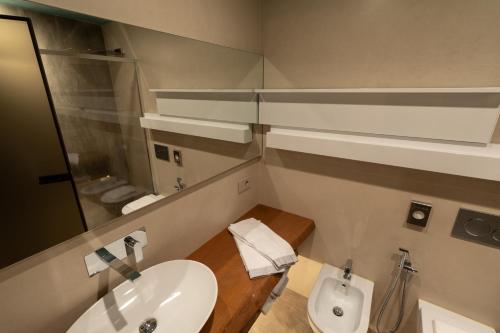 a bathroom with a sink and a mirror and a toilet at Il Vigneto in Roddi