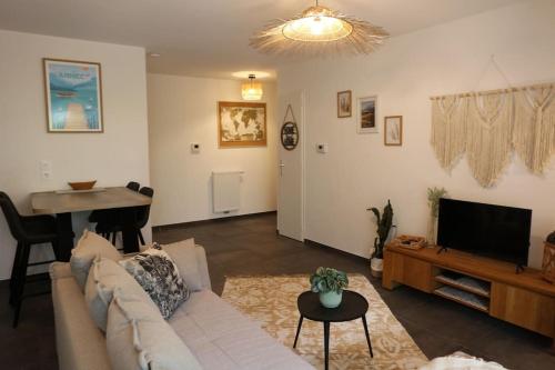 a living room with a couch and a flat screen tv at T3, à 5 min à pied du lac Annecy in Duingt