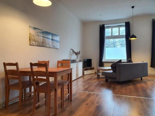 - un salon avec une table, des chaises et un canapé dans l'établissement Koala-1-5-Personen, à Brunsbüttel