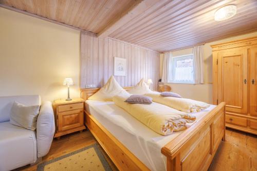 a bedroom with a large bed and a couch at Gästehaus Burghartswieser in Bernau am Chiemsee