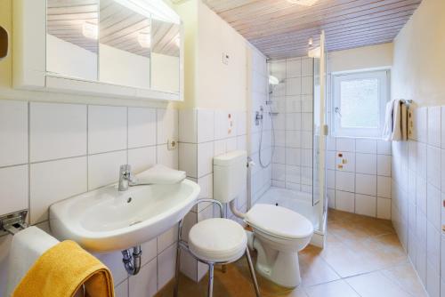 a white bathroom with a sink and a toilet at Gästehaus Burghartswieser in Bernau am Chiemsee
