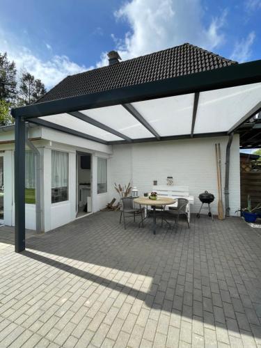 a pavilion with a table and chairs on a patio at Trentseeparadies in Plön