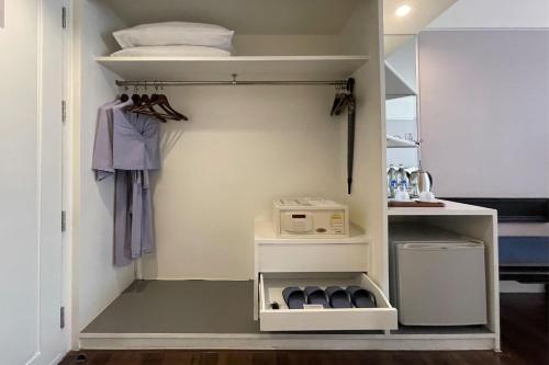 a walk in closet with white shelves at Le Siam Hotel Silom Bangkok by PCL in Bangkok