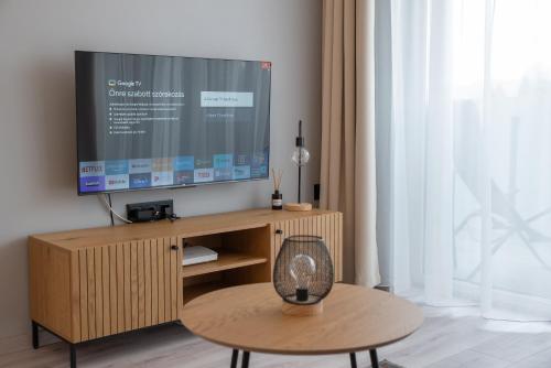 凱斯特海伊的住宿－Marina Luxury Aparment，客厅配有木架上的电视