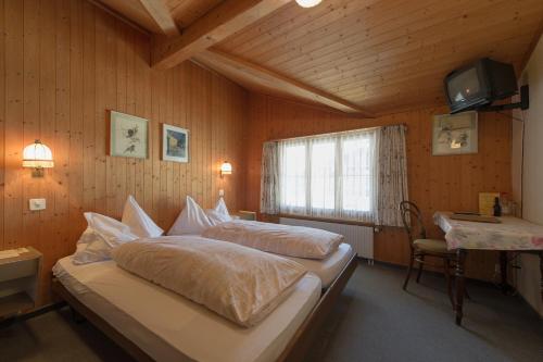 una camera da letto con un grande letto in una camera in legno di Hostel Chalet Stöckli mit Etagendusche a Wilderswil