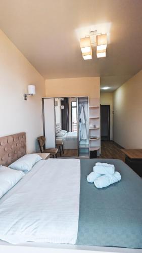 a bedroom with a large bed with two towels on it at GG ApartHotel in Batumi