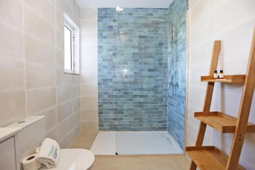 een badkamer met een douche, een toilet en een wastafel bij B75 - Casa Delfim in Alfanzina Carvoeiro in Poço Partido