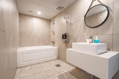 a bathroom with a white sink and a mirror at Browndot Samcheonpo in Sacheon