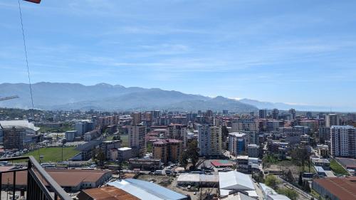 a city with buildings and mountains in the background at GG ApartHotel in Batumi