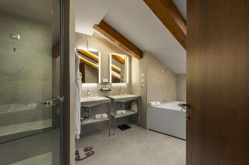 a large bathroom with two sinks and a tub at Il Boscareto Resort & Spa in Serralunga d'Alba